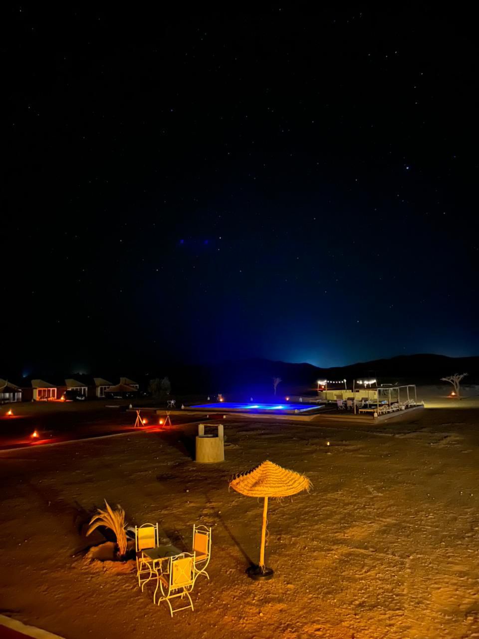 Outdoor pool under the Sahara stars at night – Sahara Royal Resort Merzouga
