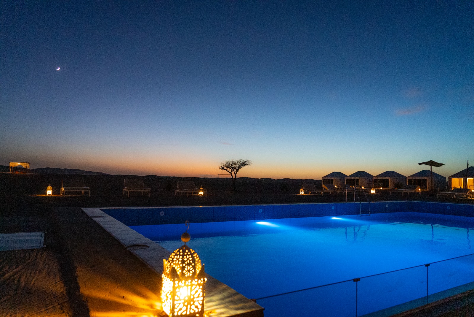 Outdoor swimming pool at sunset – luxury desert camp Merzouga, Sahara Royal Resort