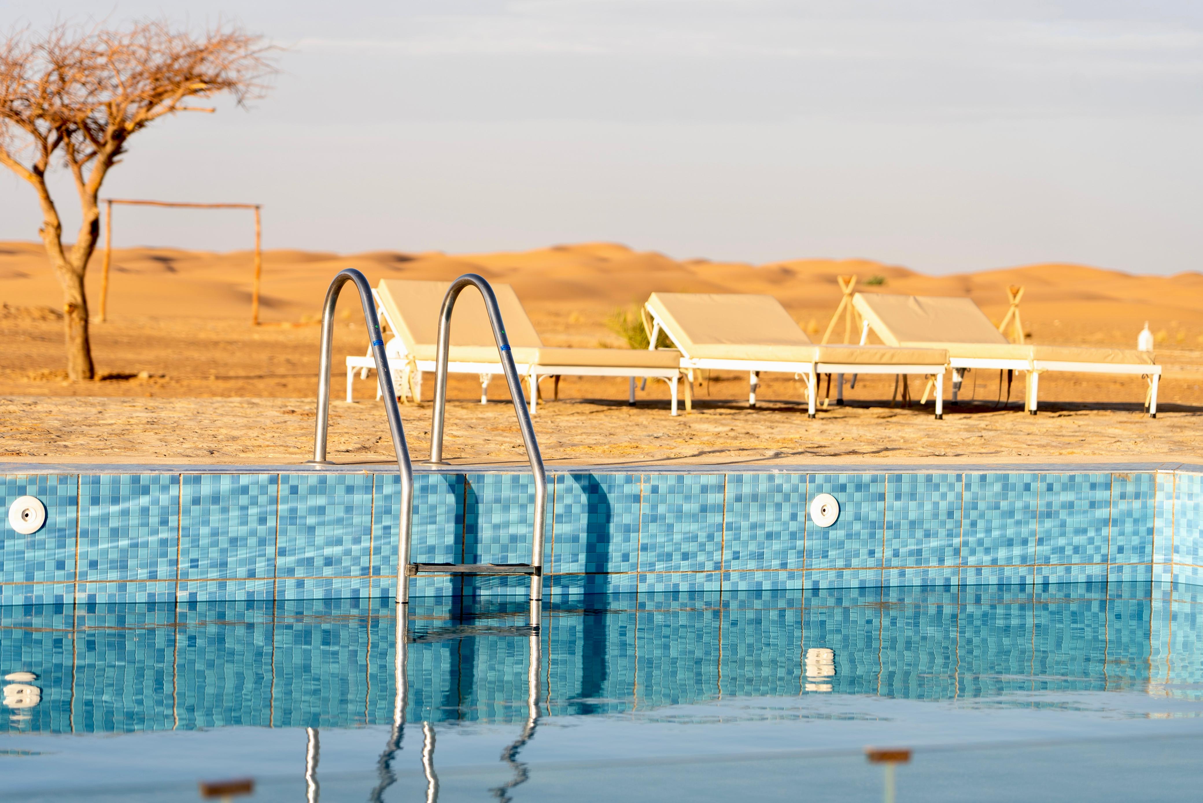Poolside lounge area – luxury desert glamping camp Merzouga Morocco